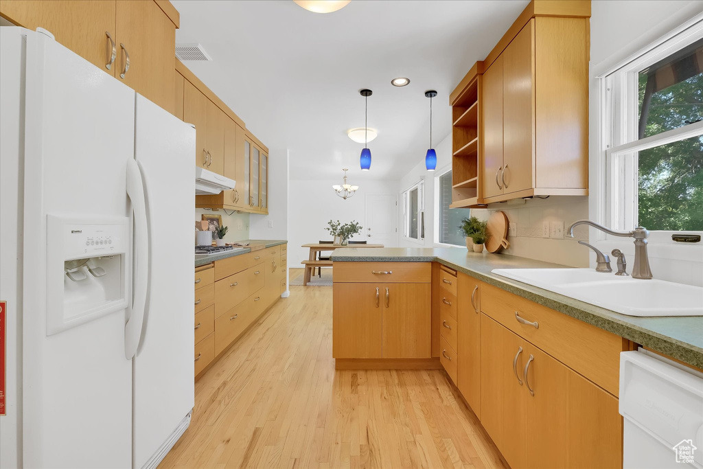 Kitchen featuring white fridge with ice dispenser, dishwasher, a peninsula, light wood finished floors, and under cabinet range hood