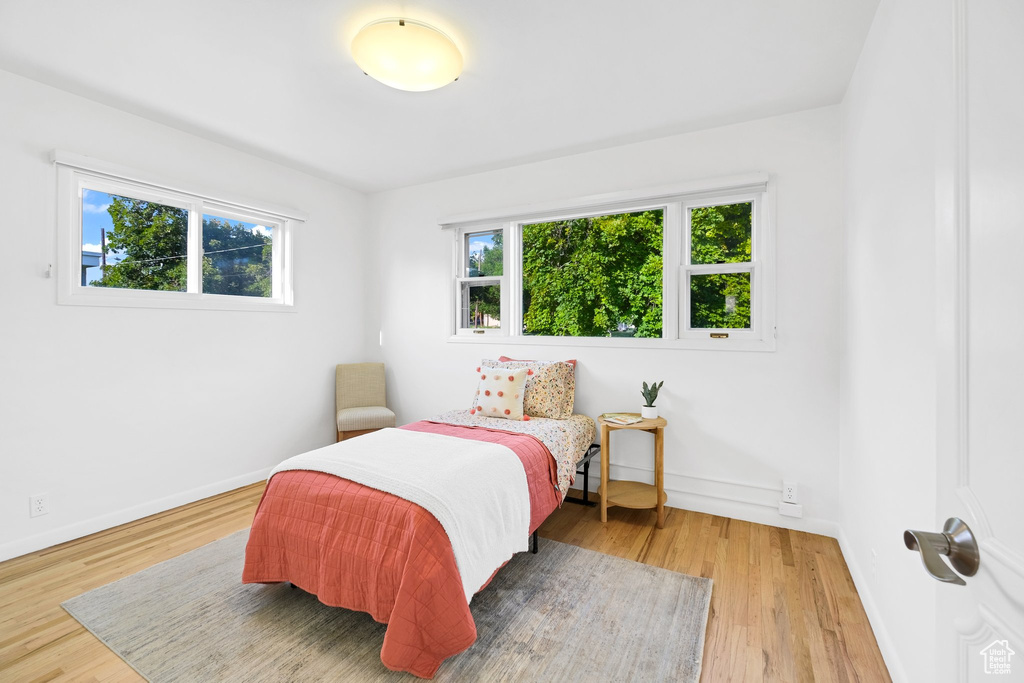Bedroom with multiple windows and wood finished floors