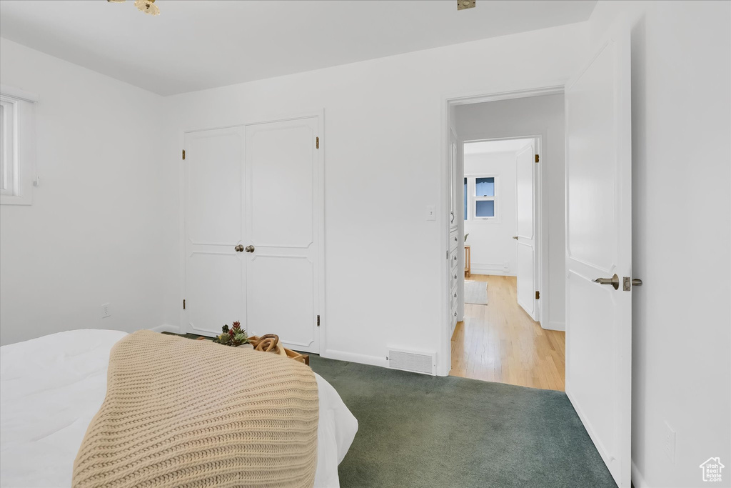 Carpeted bedroom featuring a closet and baseboards