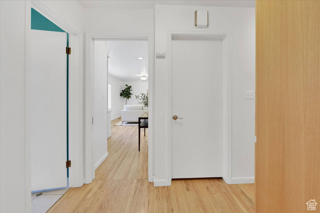 Corridor featuring light wood-style flooring and baseboards