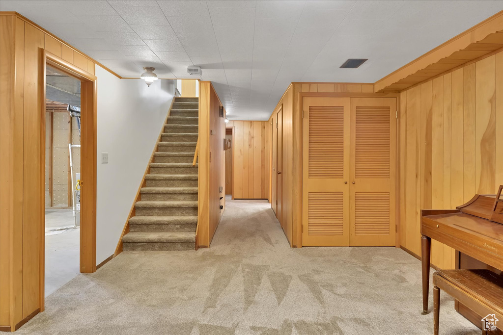 Stairway featuring carpet floors and wood walls