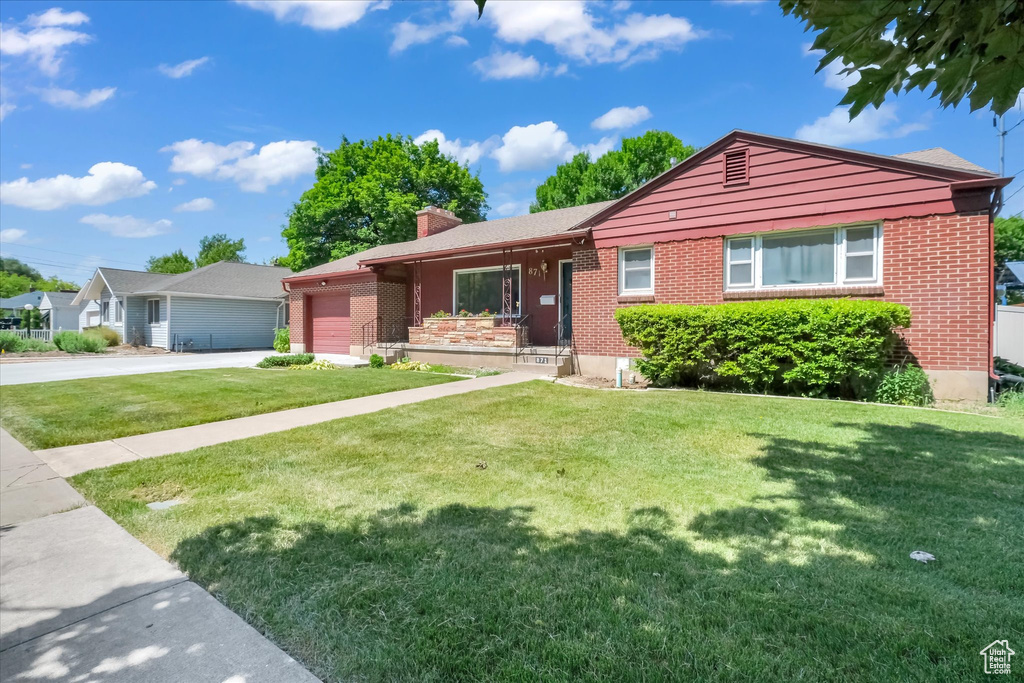 Ranch-style house with a chimney, a garage, driveway, and a front yard