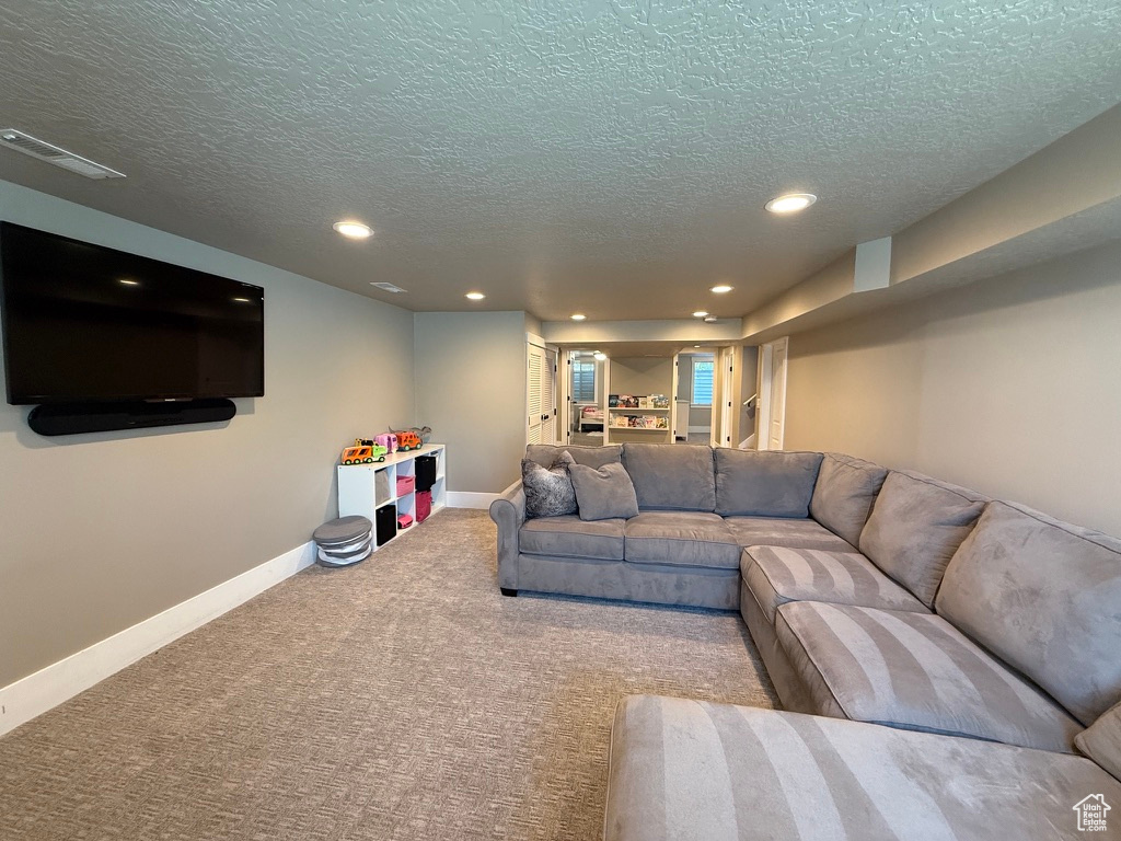 Carpeted living room with a textured ceiling and recessed lighting