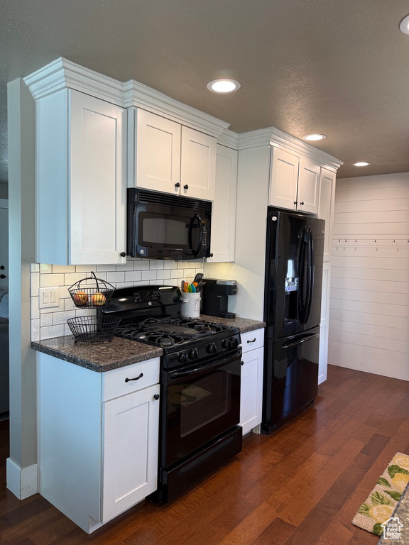 Kitchen with black appliances, dark wood-style floors, decorative backsplash, white cabinetry, and recessed lighting
