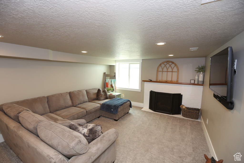 Living room featuring recessed lighting, carpet floors, a textured ceiling, and a fireplace