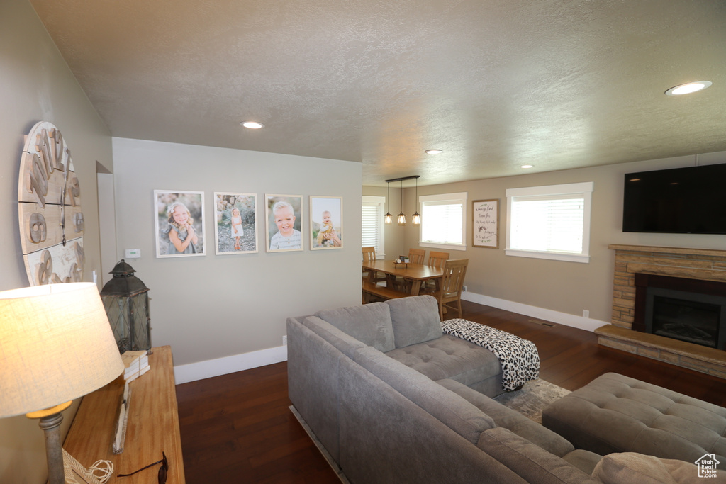Living area featuring recessed lighting, wood finished floors, a fireplace, and a textured ceiling