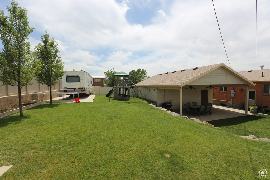View of yard with a patio, a playground, and ceiling fan
