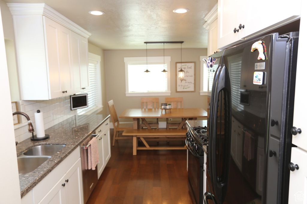 Kitchen featuring black appliances, dark wood finished floors, white cabinetry, backsplash, and recessed lighting