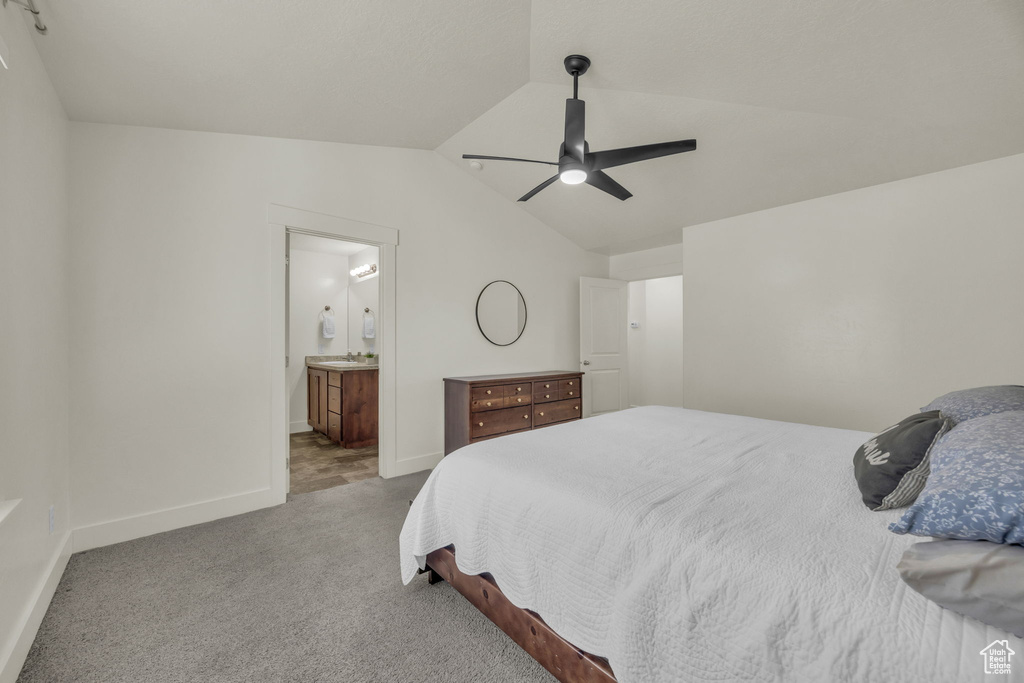 Carpeted bedroom with vaulted ceiling, ensuite bathroom, and a ceiling fan