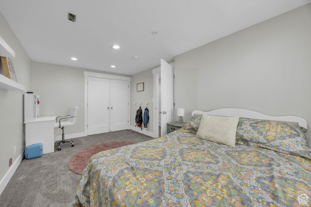 Carpeted bedroom with recessed lighting and a closet