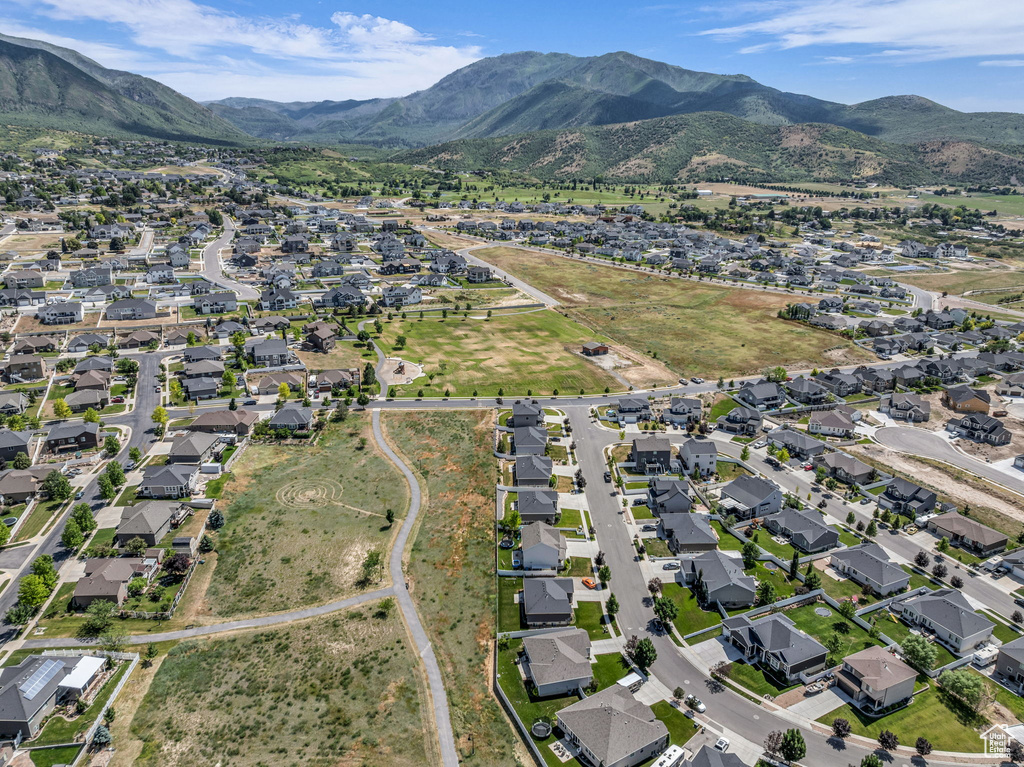 Aerial view of property and surrounding area with nearby suburban area and a mountain backdrop