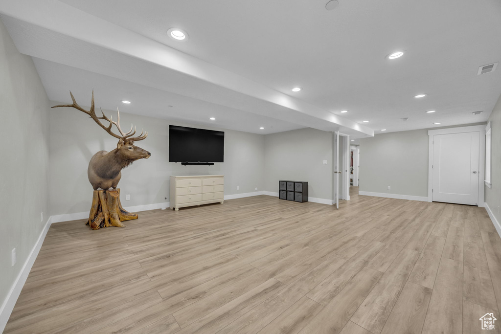 Finished below grade area with light wood finished floors and recessed lighting