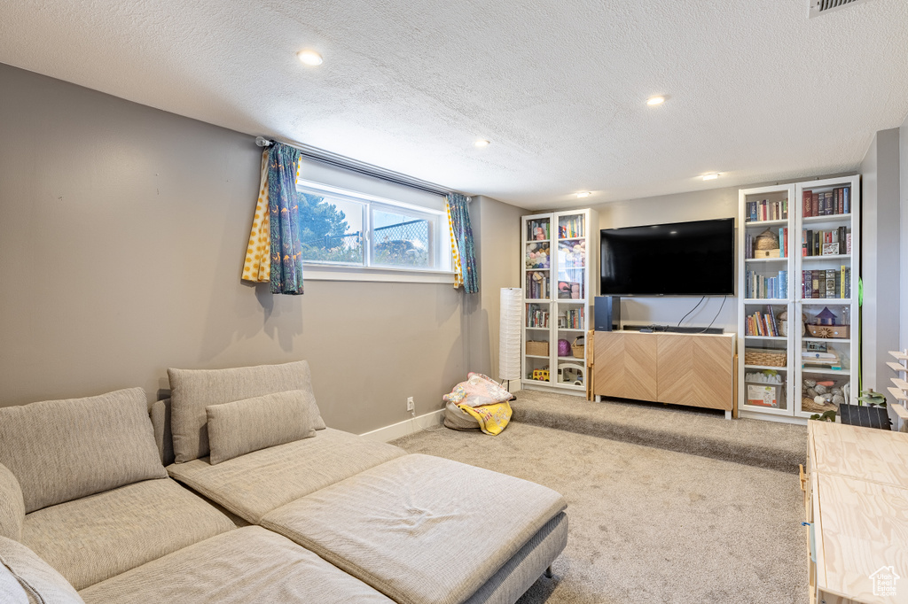 Living room featuring carpet flooring, a textured ceiling, and recessed lighting
