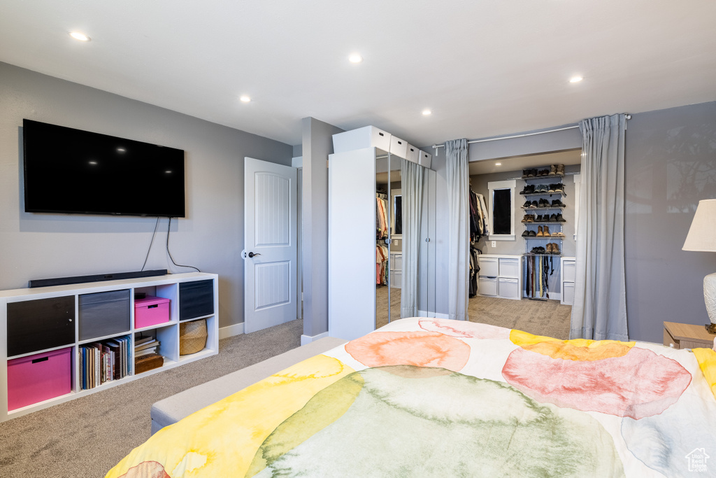 Carpeted bedroom with recessed lighting, bar area, and a closet