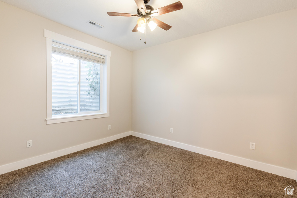 Spare room with dark carpet and ceiling fan