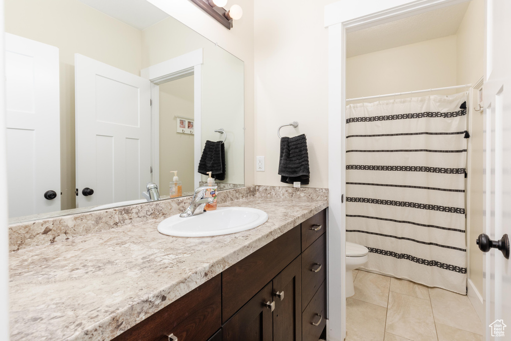 Bathroom with vanity, tile patterned flooring, and a shower with shower curtain