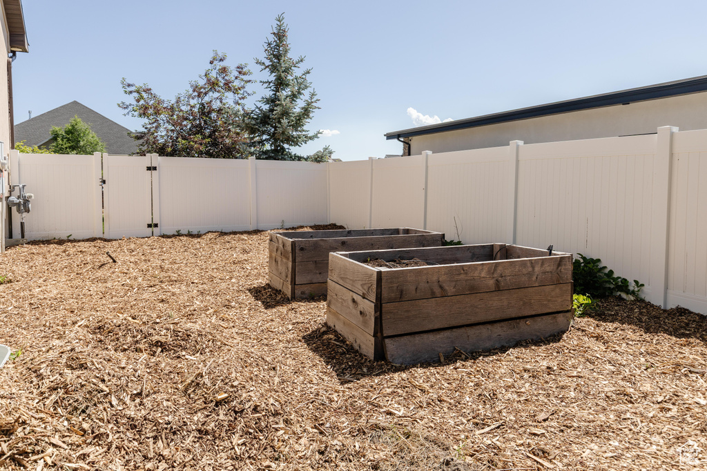 Fenced backyard with a gate and a garden