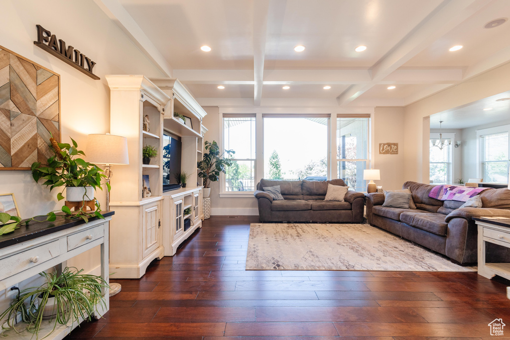 Living area featuring dark wood finished floors, beamed ceiling, coffered ceiling, recessed lighting, and a chandelier