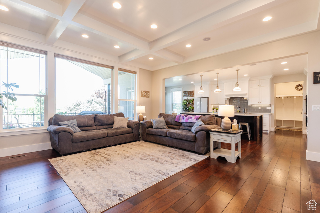 Living room featuring dark wood-type flooring, coffered ceiling, plenty of natural light, recessed lighting, and beamed ceiling