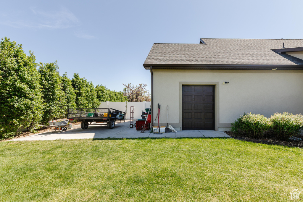 Rear view of property with stucco siding, a shingled roof, and a patio area