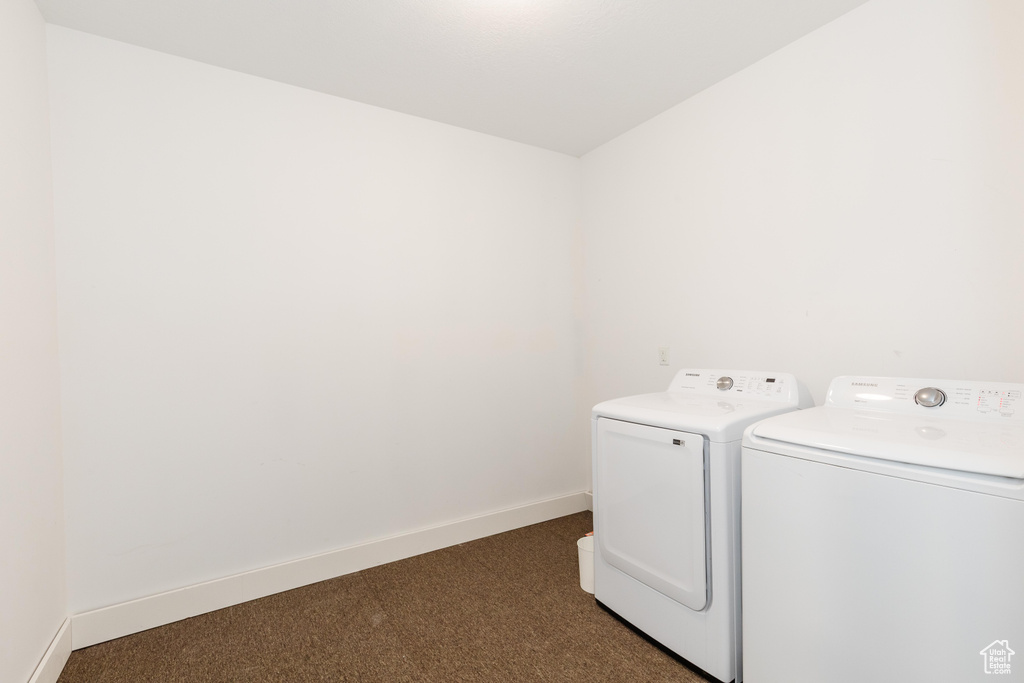 Washroom featuring washing machine and clothes dryer and dark carpet