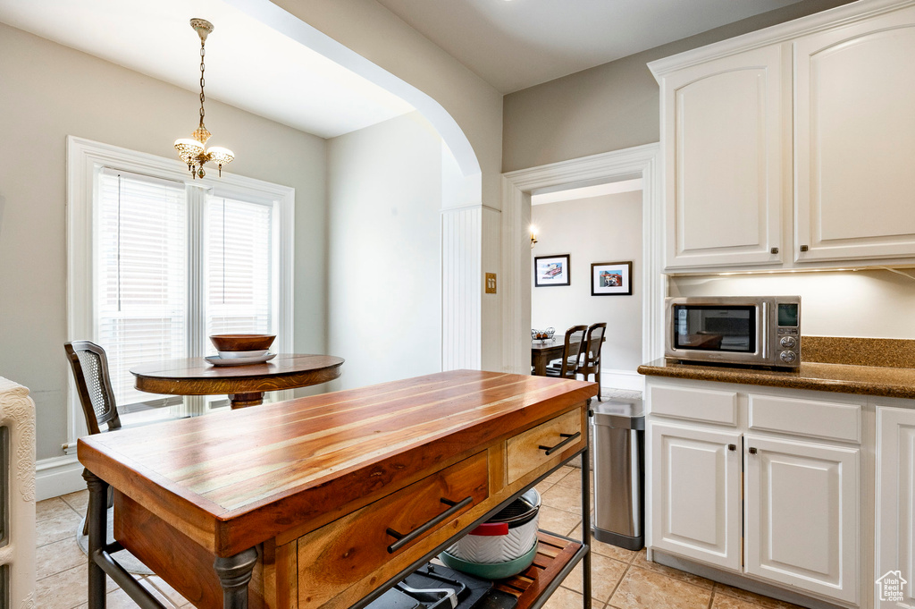 Dining area with arched walkways and light tile patterned floors