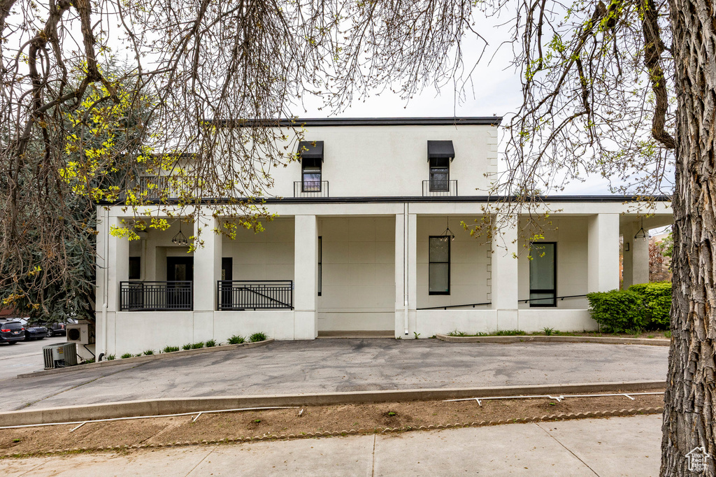 View of front of home with stucco siding and covered porch