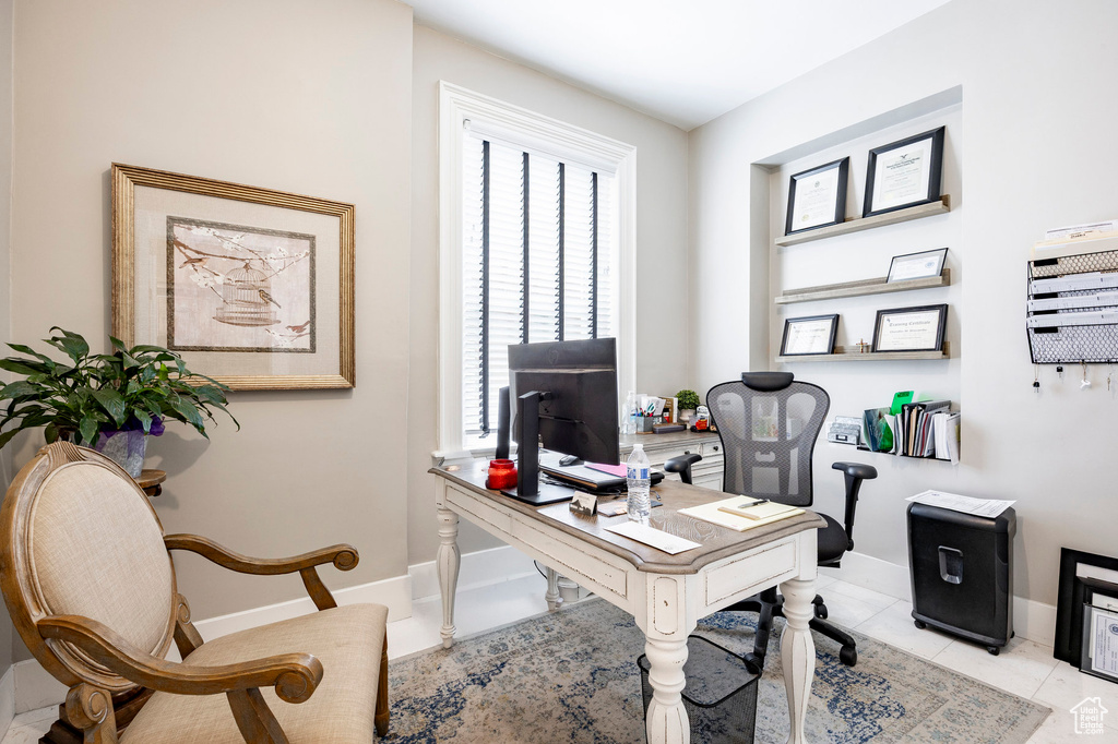 Office area with baseboards and light tile patterned flooring
