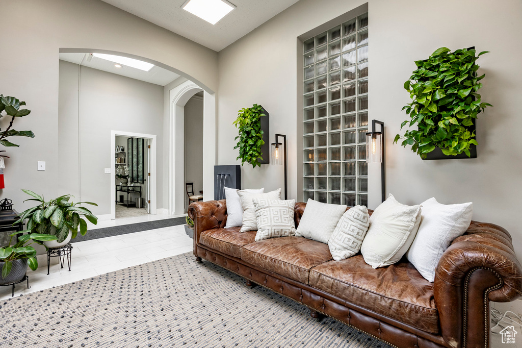 Living area with arched walkways, tile patterned floors, and baseboards