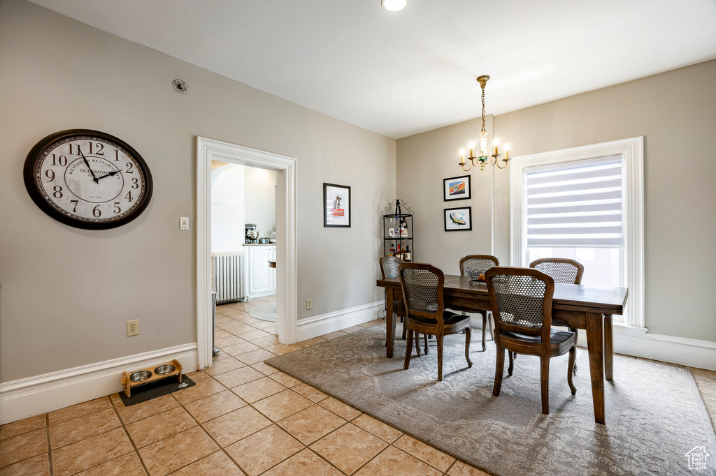 Dining space featuring a chandelier, light tile patterned floors, and baseboards