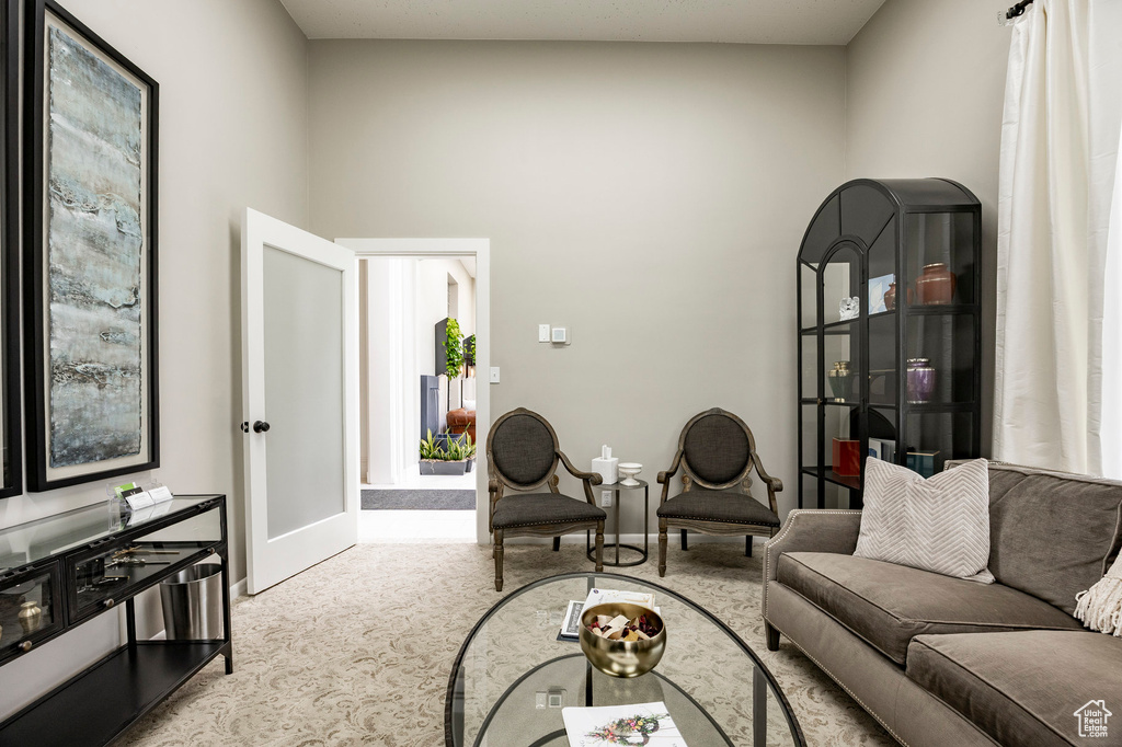 Living room with carpet flooring, french doors, baseboards, and a high ceiling
