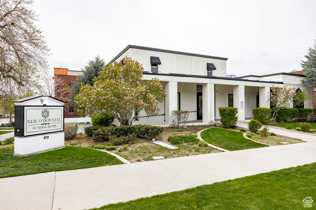 View of front of property with stucco siding and a front lawn