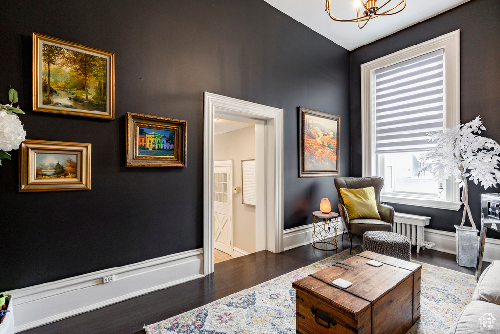 Living area featuring a chandelier, wood finished floors, and baseboards