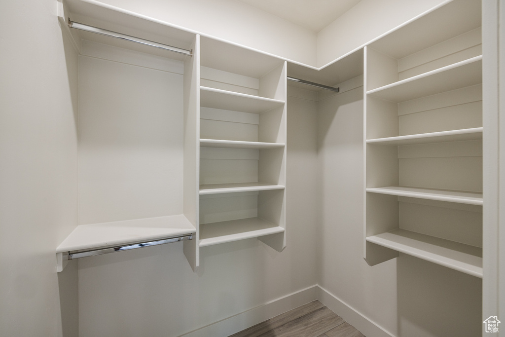 Walk in closet with wood finished floors