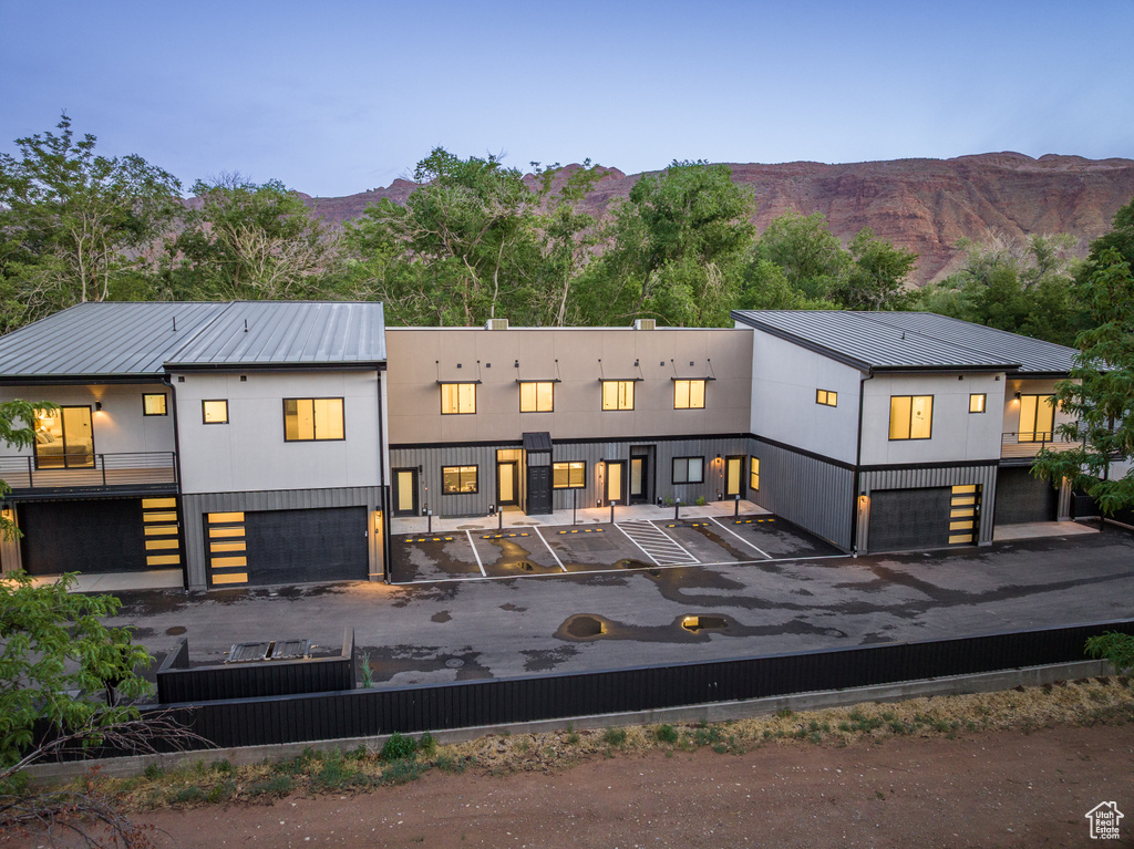 Rear view of property featuring metal roof, a mountain view, and uncovered parking