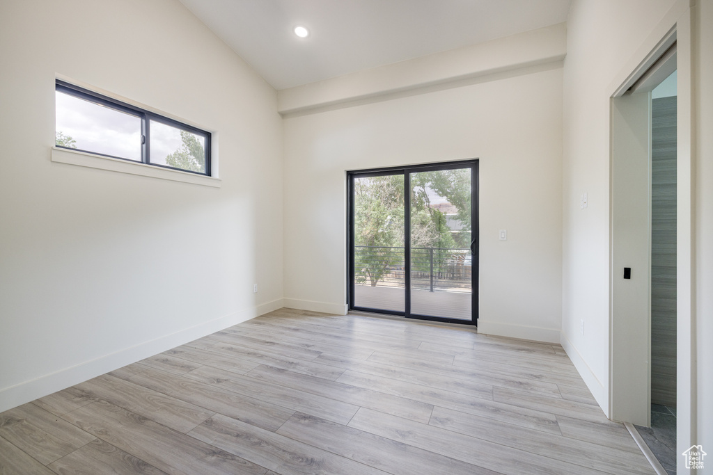 Empty room featuring healthy amount of natural light, light wood-style flooring, recessed lighting, and baseboards