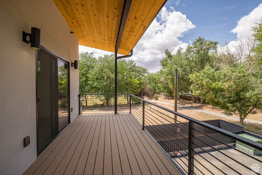 Wooden terrace featuring view of wooded area