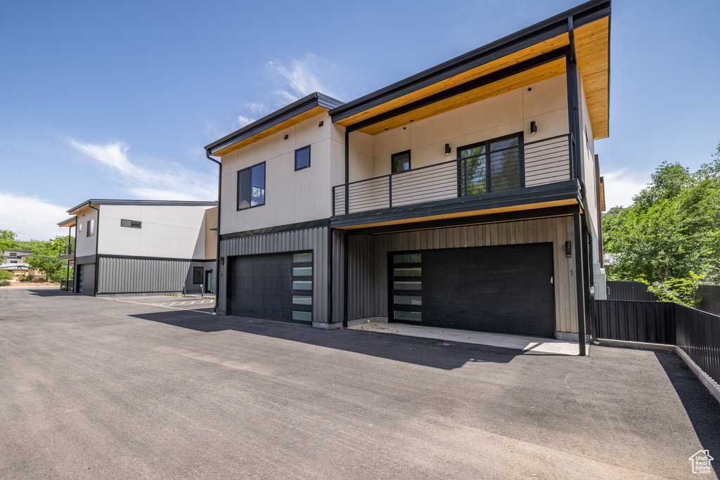 View of front of property with a balcony and a garage