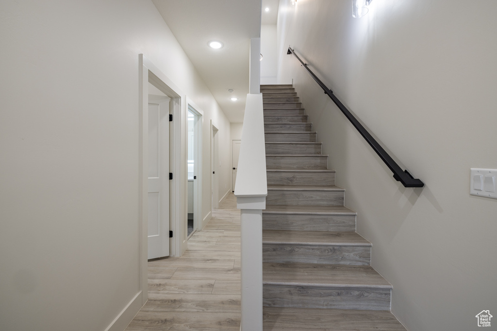 Stairway with recessed lighting and wood finished floors
