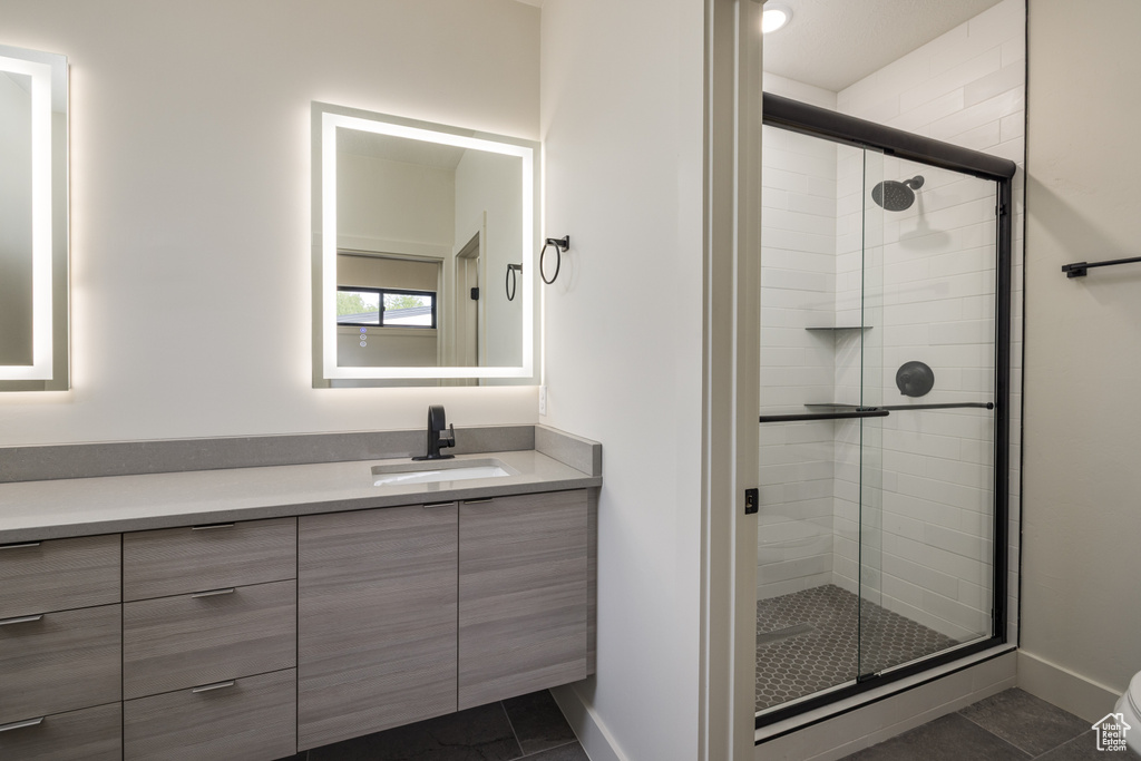 Bathroom with vanity, a shower stall, toilet, and tile patterned flooring