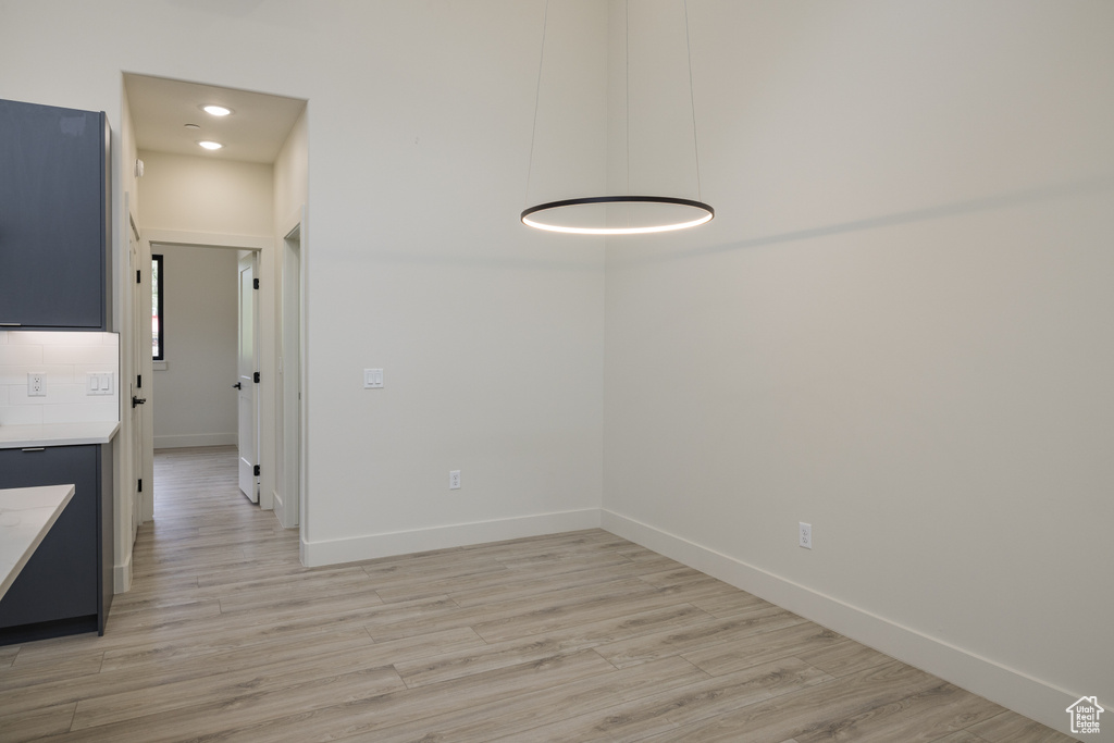 Unfurnished dining area featuring light wood-type flooring, baseboards, and recessed lighting