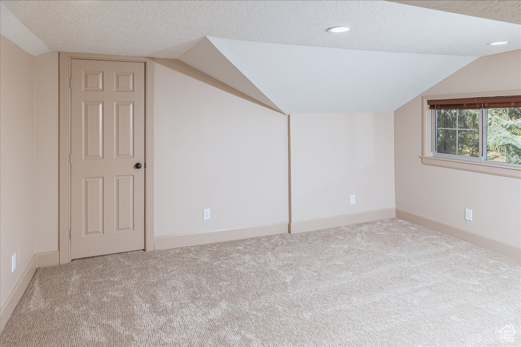 Bonus room featuring vaulted ceiling, a textured ceiling, carpet, and recessed lighting