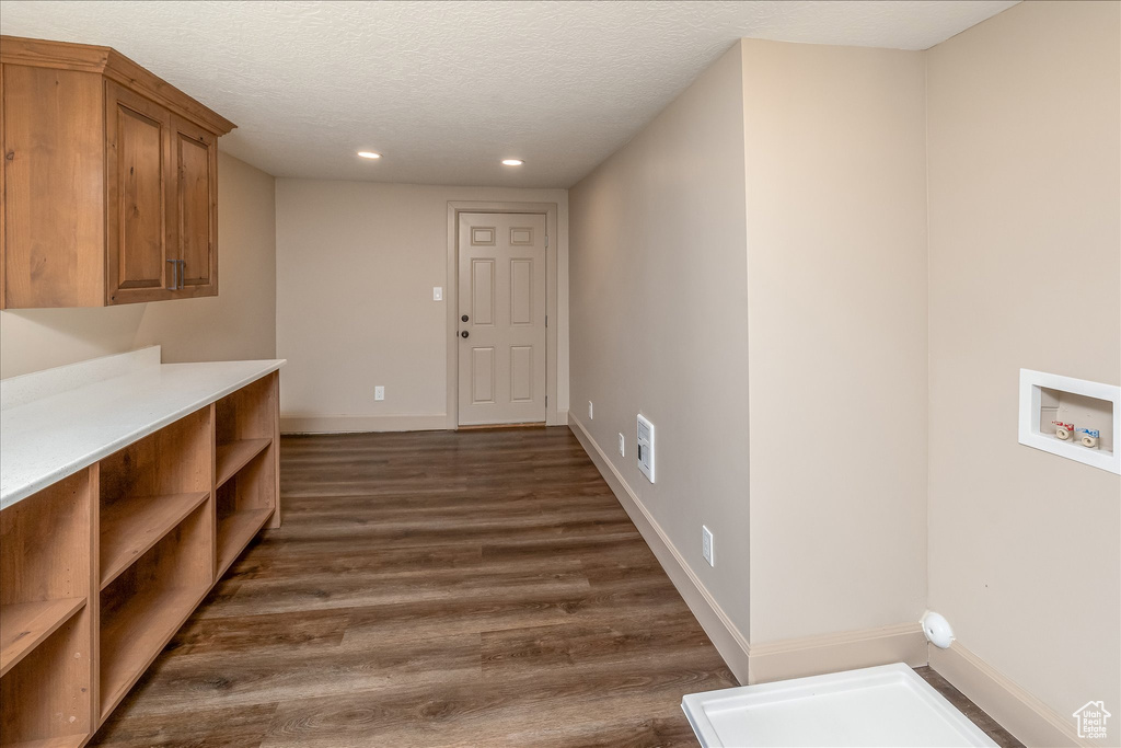 Laundry room featuring recessed lighting, hookup for a washing machine, dark wood finished floors, a textured ceiling, and cabinet space