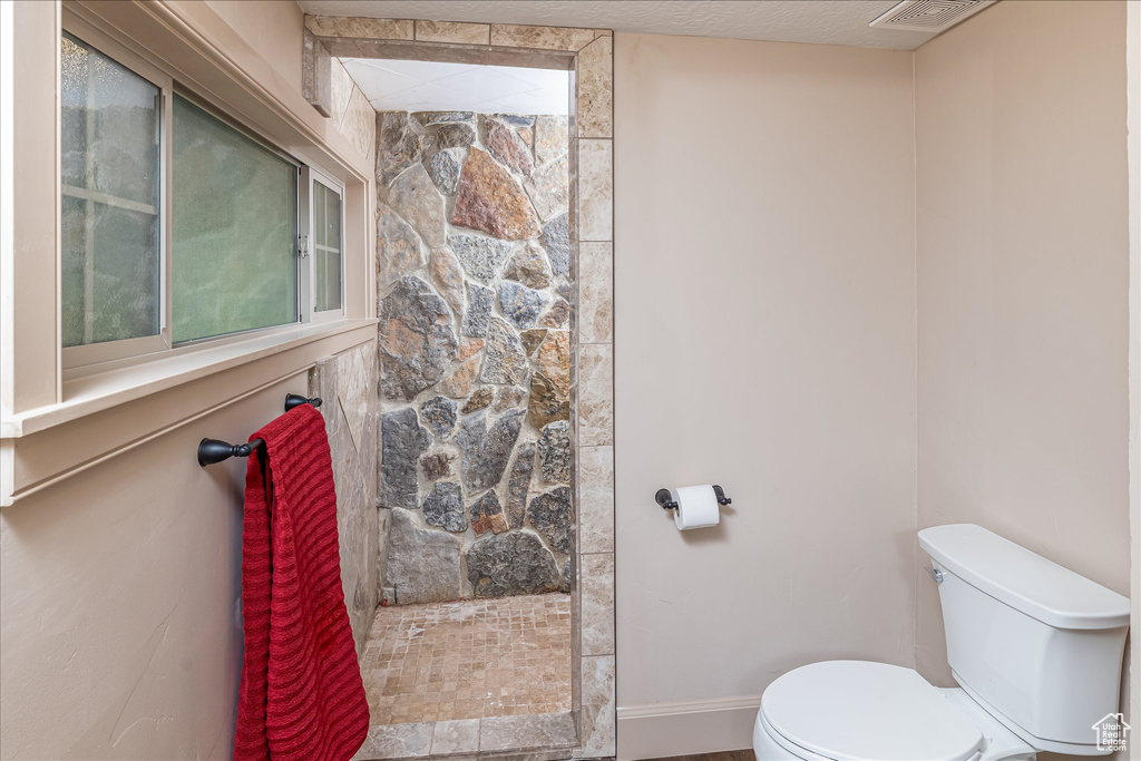 Bathroom with toilet and tiled shower