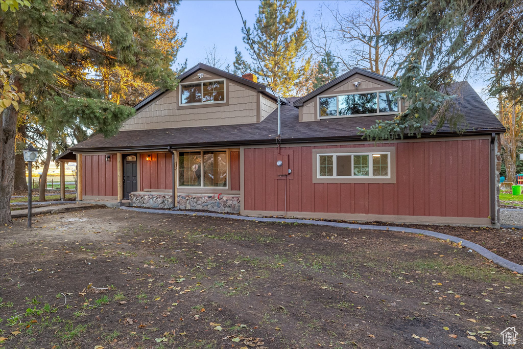 View of front of house with roof with shingles and board and batten siding