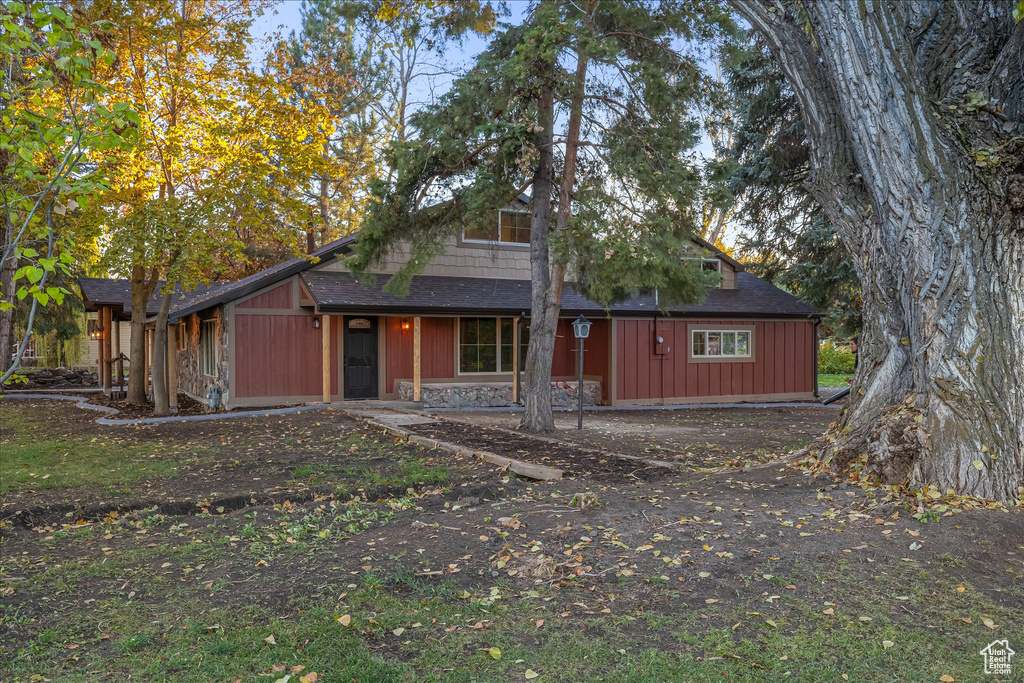 View of front of house featuring a shingled roof and stone siding