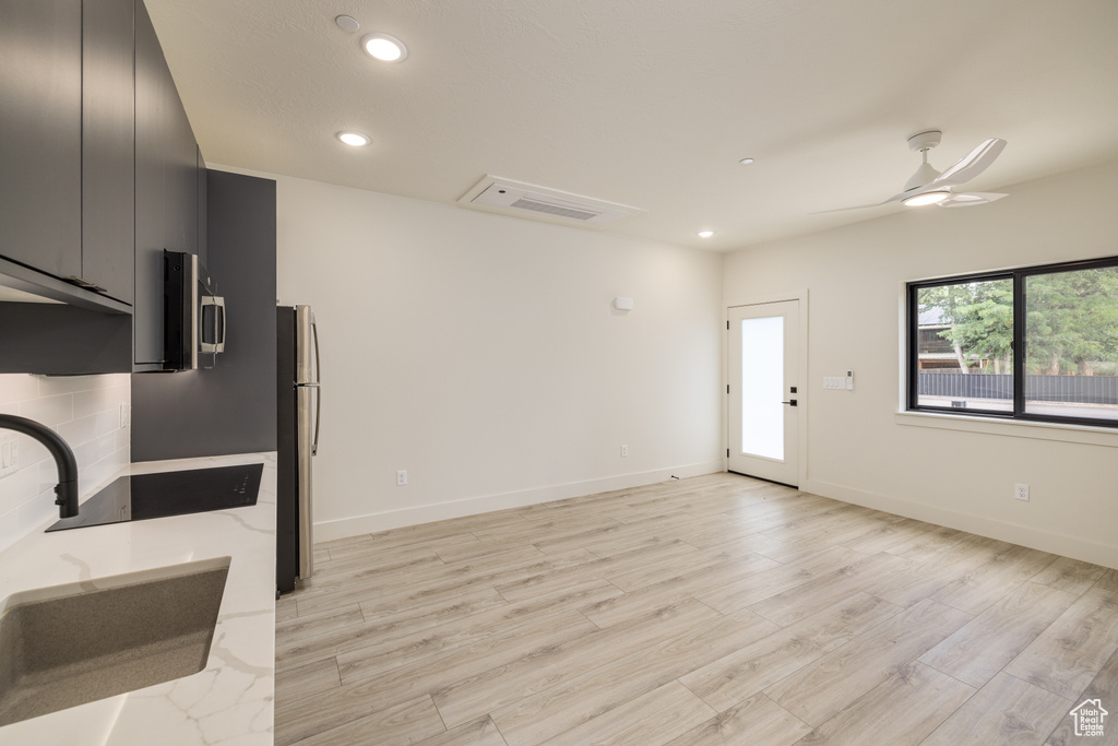 Kitchen with a sink, dark cabinetry, appliances with stainless steel finishes, recessed lighting, and light wood-style flooring