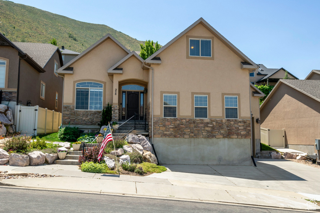 View of front facade featuring stone siding, stucco siding, and a mountain view