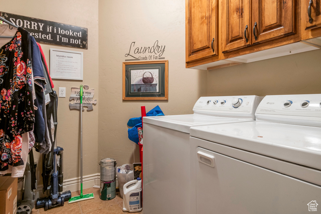 Laundry area with washer and clothes dryer, cabinet space, and tile patterned floors