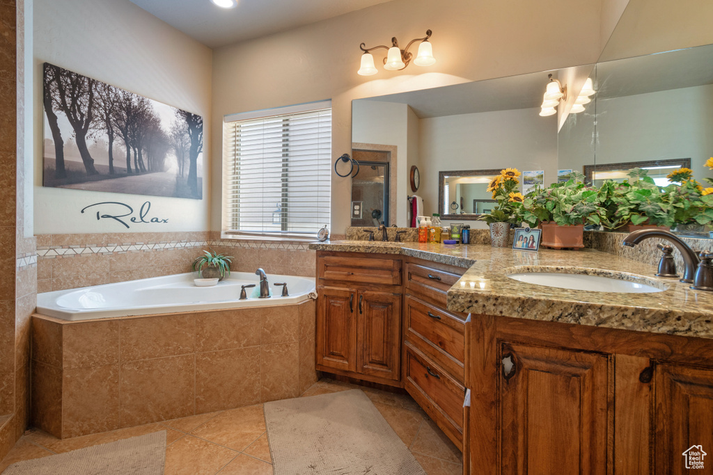 Full bathroom with tile patterned flooring, double vanity, and a garden tub